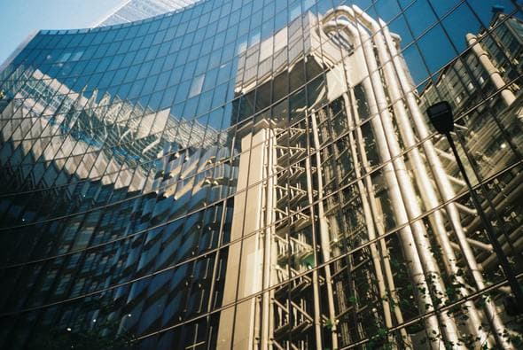 The Lloyd's building reflected across a glass facade